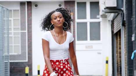 Fashionable-young-black-woman-wearing-red-polka-dot-trousers-dancing-in-the-street