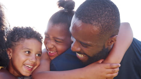 Black-parents-piggybacking-their-young-kids,-close-up