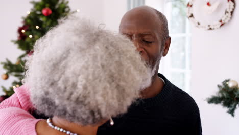 Close-up-of-senior-black-couple-dancing-in-their-living-room-on-Christmas-day,-selective-focus,-close-up