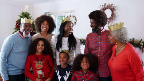 Retrato-De-Una-Familia-Multigeneracional-Con-Sombreros-De-Papel-Celebrando-La-Navidad-Juntos-En-Casa