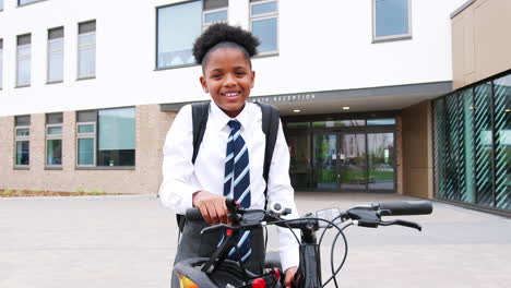 Portrait-Of-Female-High-School-Student-Wearing-Uniform-With-Bicycle-Outside-School-Buildings