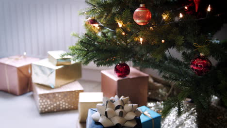 Schrägaufnahme-Von-Kugeln,-Die-An-Einem-Weihnachtsbaum-Hängen,-Und-Darunter-Angeordneten-Geschenken,-Nahaufnahme