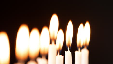 Rack-Fokus-Detailaufnahme-Der-Flammen-Auf-Einer-Reihe-Von-Neun-Weißen-Kerzen,-Die-Am-Jüdischen-Feiertag-Von-Chanukka-Brennen