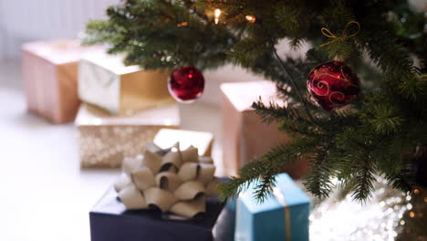 Geschenke-Unter-Einem-Geschmückten-Weihnachtsbaum-Mit-Roten-Kugeln,-Nahaufnahme,-Rack-Fokus