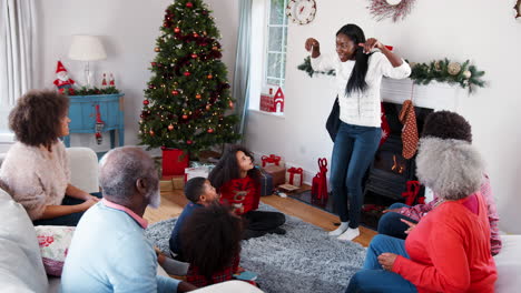 Familia-Multigeneracional-Jugando-A-Charadas-Mientras-Celebran-La-Navidad-Juntos-En-Casa