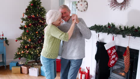 Romantisches-älteres-Paar,-Das-Zu-Hause-Zusammen-Tanzt,-Mit-Weihnachtsbaum-Im-Hintergrund