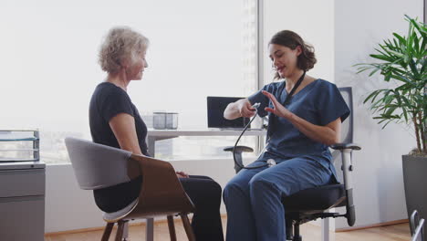 Ärztin-Trägt-Kittel-Im-Büro-Und-Hört-Der-Brust-älterer-Patientinnen-Mit-Stethoskop-Zu