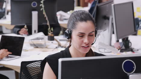 Female-Customer-Services-Agent-Working-At-Desk-In-Call-Center