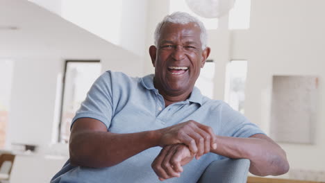 Laughing-Senior-Man-Relaxing-On-Sofa-At-Home