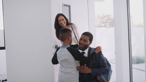 Business-Couple-Greeting-Son-As-They-Open-Front-Door-Of-House-On-Return-Home