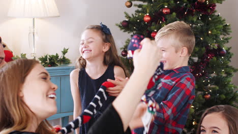 Niños-Dando-Regalos-A-Sus-Padres-Mientras-Celebran-Juntos-El-Día-De-Navidad-En-Casa