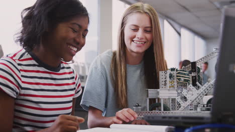 Two-Female-College-Students-Building-Machine-In-Science-Robotics-Or-Engineering-Class