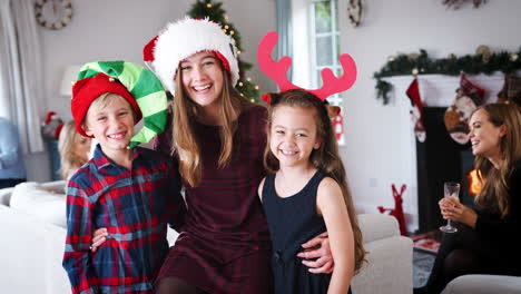 Portrait-Of-Children-Wearing-Christmas-Hats-As-Multi-Generation-Family-And-Friends-Celebrate-At-House-Party