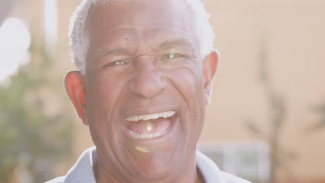 Outdoor-Head-And-Shoulders-Portrait-Of-Laughing-Senior-Man