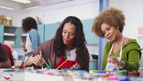 Two-Mature-Female-Students-Attending-Art-Class-In-Community-Centre