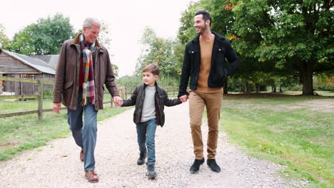 Grandfather-With-Son-And-Grandson-On-Autumn-Walk-In-Countryside-Together
