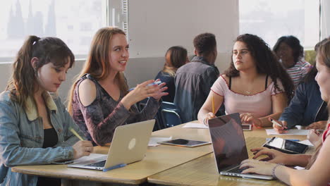 Gruppe-Weiblicher-College-Studenten,-Die-Am-Schreibtisch-Sitzen-Und-Laptops-Nutzen,-Um-Gemeinsam-An-Einem-Projekt-Zu-Arbeiten