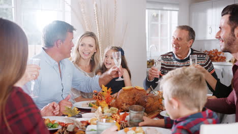 Mehrgenerationenfamilie-Sitzt-Am-Tisch-Und-Stößt-An,-Während-Sie-Zu-Hause-Gemeinsam-Das-Erntedankfest-Isst