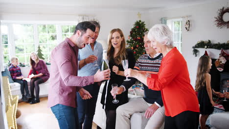 Mehrgenerationenfamilie-Und-Freunde-Feiern-Mit-Champagner-Auf-Der-Weihnachtshausparty