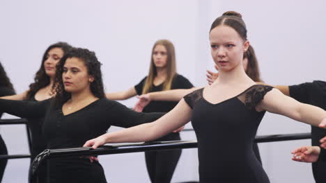 Estudiantes-Masculinos-Y-Femeninos-De-La-Escuela-De-Artes-Escénicas-Ensayando-Ballet-En-El-Estudio-De-Danza-Usando-Barra