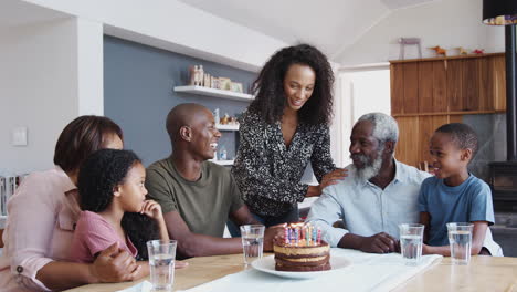 Multi-Generation-Family-Celebrating-Grandfathers-Birthday-At-Home-With-Cake-And-Candles