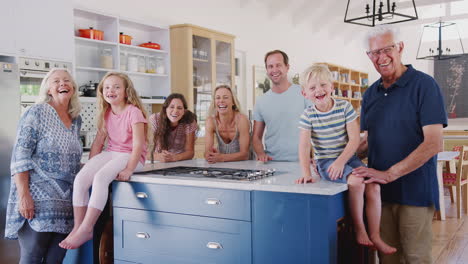 Portrait-Of-Multi-Generation-Family-Standing-Around-Kitchen-Island-Together