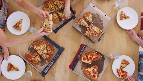 Overhead-Zeitraffer-Einer-Familie-Aus-Mehreren-Generationen,-Die-Am-Tisch-Sitzt-Und-Gemeinsam-Pizza-Isst