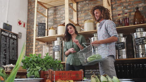 Young-Couple-Buying-Fresh-Fruit-And-Vegetables-In-Sustainable-Plastic-Free-Grocery-Store