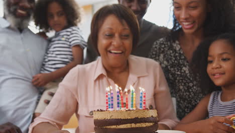 Multi-Generation-Family-Celebrating-Grandmothers-Birthday-At-Home-With-Cake-And-Candles