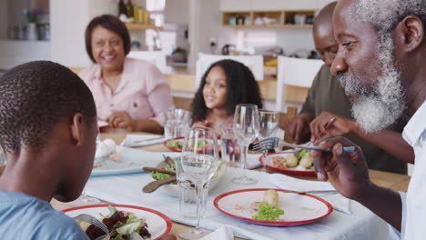 Familie-Mit-Mehreren-Generationen,-Die-Zu-Hause-Am-Tisch-Sitzt-Und-Gemeinsam-Essen-Genießt