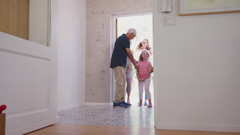 Großeltern-öffnen-Die-Haustür,-Um-Die-Familie-Mit-Mehreren-Generationen-Zu-Besuch-Willkommen-Zu-Heißen