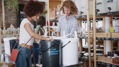 Frau-Füllt-Behälter-Mit-Spülmaschinenpulver-In-Plastikfreiem-Lebensmittelgeschäft