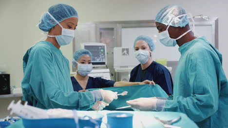 Krankenschwester-überreicht-Dem-Chirurgen-Medizinische-Instrumente,-Während-Das-Operationsteam-Im-Operationssaal-Am-Patienten-Arbeitet