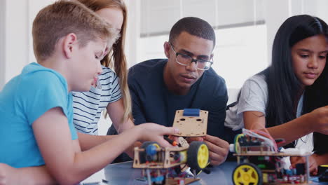 Students-With-Male-Teacher-In-After-School-Computer-Coding-Class-Learning-To-Build-Robot-Vehicle