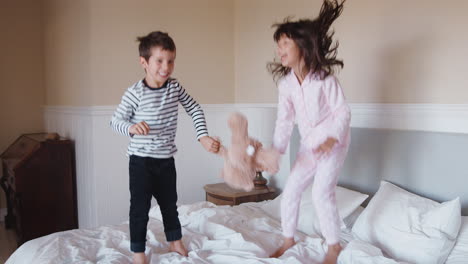 Kinder-Haben-Spaß-Daran,-Zu-Hause-Auf-Dem-Bett-Der-Eltern-Zu-Springen-Und-Zu-Spielen