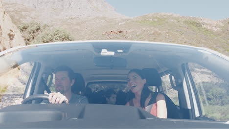 View-From-Outside-Vehicle-As-Family-Drive-Car-Along-Mountain-Road-To-Vacation-Destination