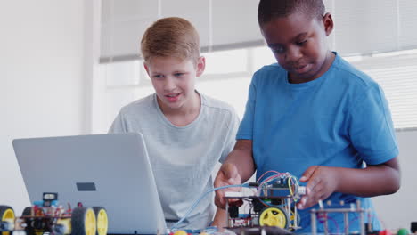Zwei-Männliche-Schüler-Bauen-Und-Programmieren-Roboterfahrzeuge-Im-Computerprogrammierungskurs-Nach-Der-Schule