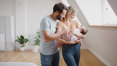 Close-Up-Of-Loving-Parents-Holding-Newborn-Baby-Son-At-Home-In-Loft-Apartment