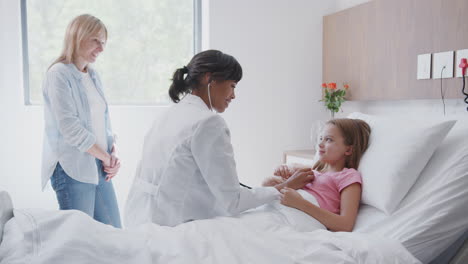 Ärztin-Hört-Mädchen-Auf-Die-Brust,-Während-Sie-Mutter-Und-Tochter-Auf-Der-Krankenstation-Besucht
