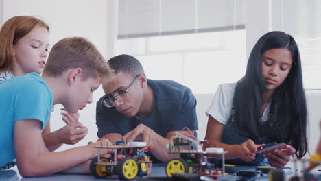 Students-With-Male-Teacher-In-After-School-Computer-Coding-Class-Learning-To-Program-Robot-Vehicle
