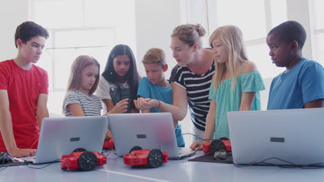 Students-With-Female-Teacher-In-After-School-Computer-Coding-Class-Learning-To-Program-Robot-Vehicle