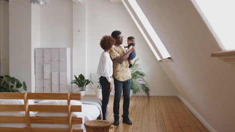Loving-Parents-Holding-Newborn-Baby-Son-At-Home-In-Loft-Apartment