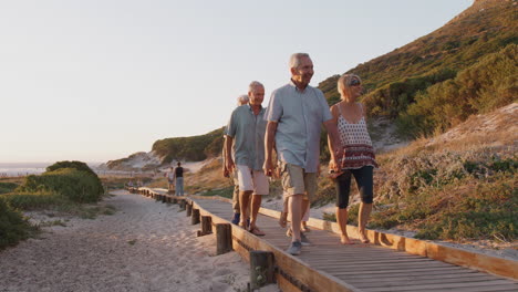 Gruppe-älterer-Freunde,-Die-Im-Sommergruppenurlaub-Die-Strandpromenade-Entlang-Spazieren