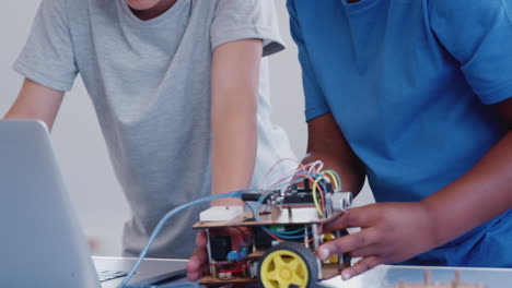 Dos-Estudiantes-Varones-Construyen-Y-Programan-Un-Vehículo-Robot-En-Una-Clase-De-Codificación-Informática-Después-De-La-Escuela