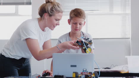 Male-Student-With-Teacher-Building-Robot-Vehicle-In-After-School-Computer-Coding-Class