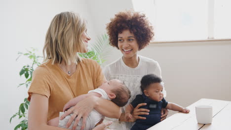 Zwei-Mütter-Mit-Babys-Treffen-Sich-Zu-Hause-Zum-Spieltermin-Am-Tisch