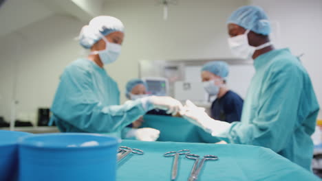 La-Enfermera-Entrega-Instrumentos-Médicos-Al-Cirujano-Mientras-El-Equipo-Quirúrgico-Trabaja-Con-El-Paciente-En-El-Quirófano.