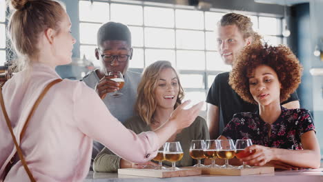 Waitress-Serving-Group-Of-Friends-At-Beer-Tasting-In-Bar