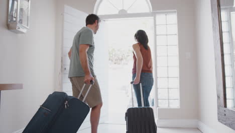 Family-With-Luggage-Opening-Front-Door-And-Leaving-For-Vacation