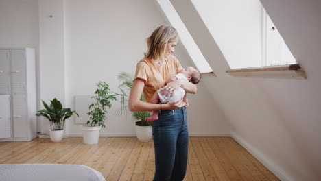 Loving-Mother-Holding-Sleeping-Newborn-Baby-At-Home-In-Loft-Apartment